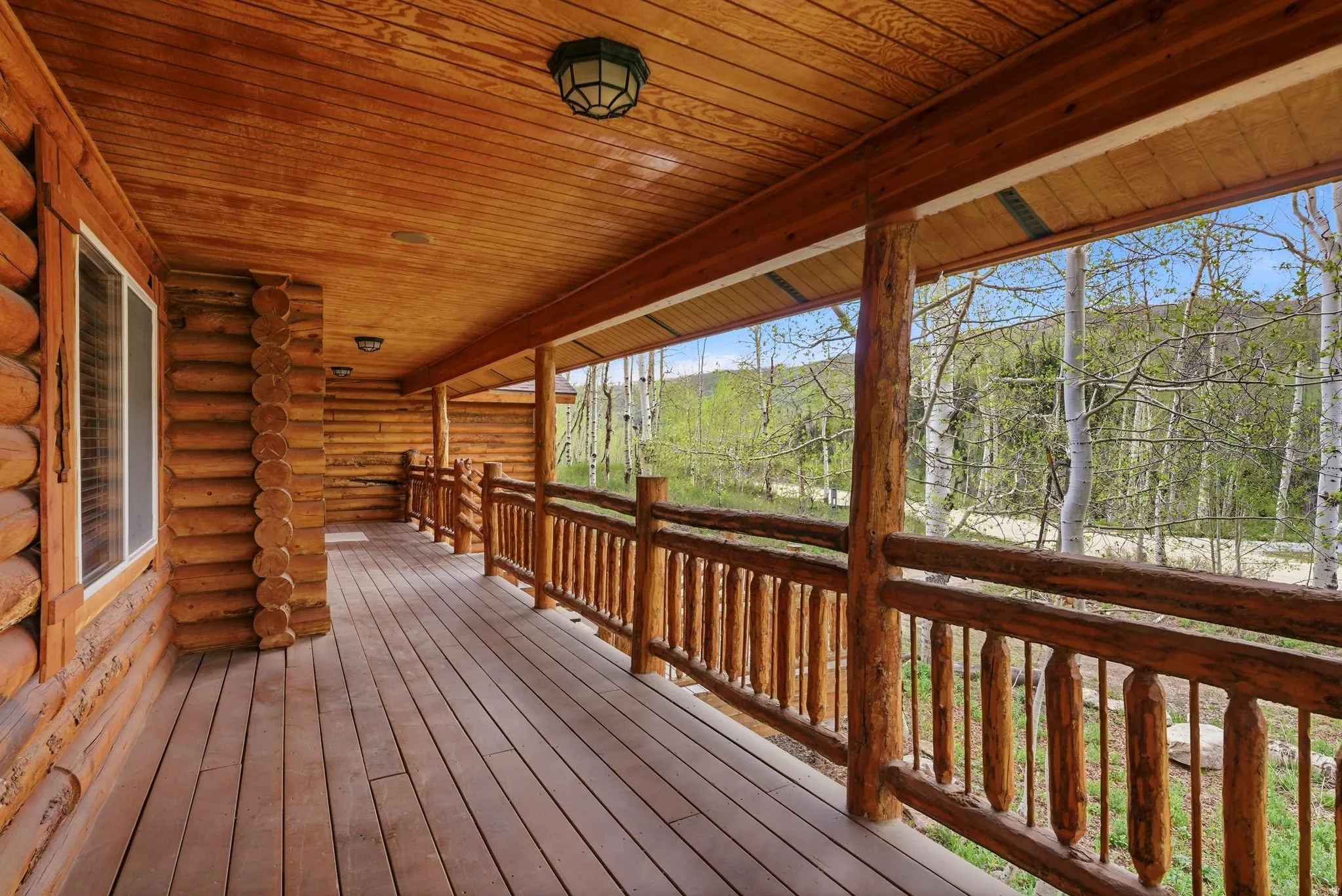 Expansive porch featuring natural wood log construction