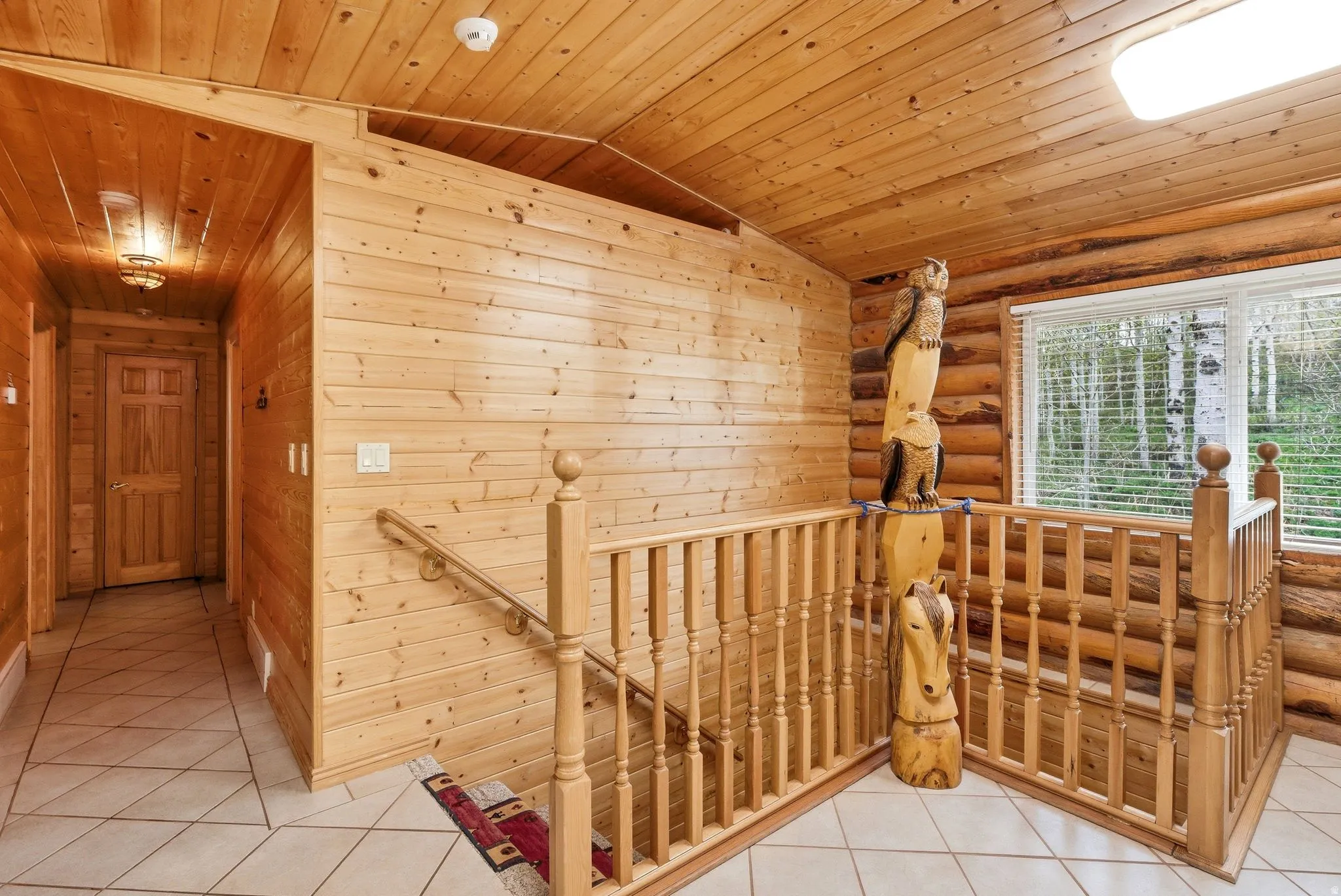 Wood-paneled interiors featuring a staircase with wood balusters and posts