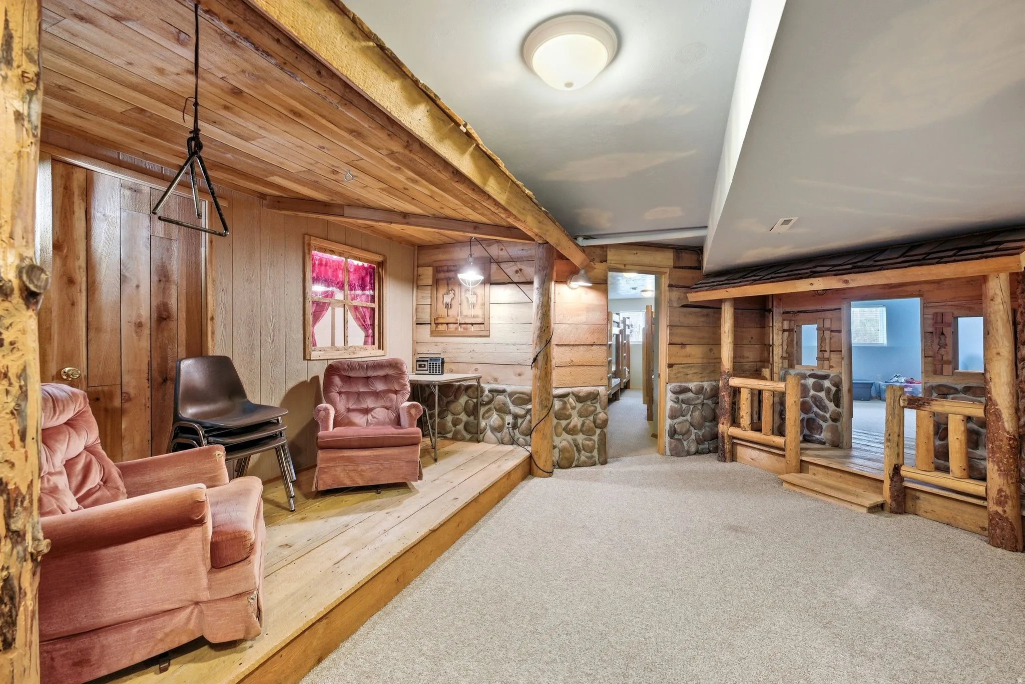 Finished basement recreation area featuring extensive wood-finish paneling and log-style architectural details