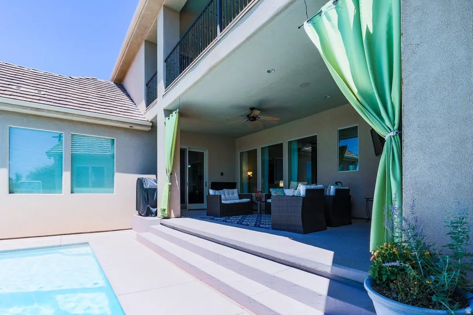 Covered patio featuring recessed lighting, a ceiling fan, and multiple sliding glass doors