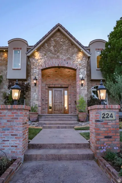 Stone and brick-clad facade featuring a grand arched entryway