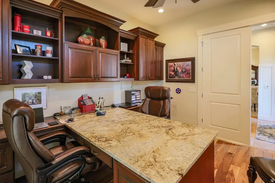 Dedicated office space featuring a built-in L-shaped desk with a stone countertop