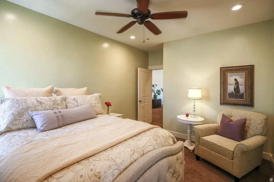 Bedroom featuring a ceiling fan with integrated lighting, recessed ceiling lights, a tufted headboard, and a neutral wall color
