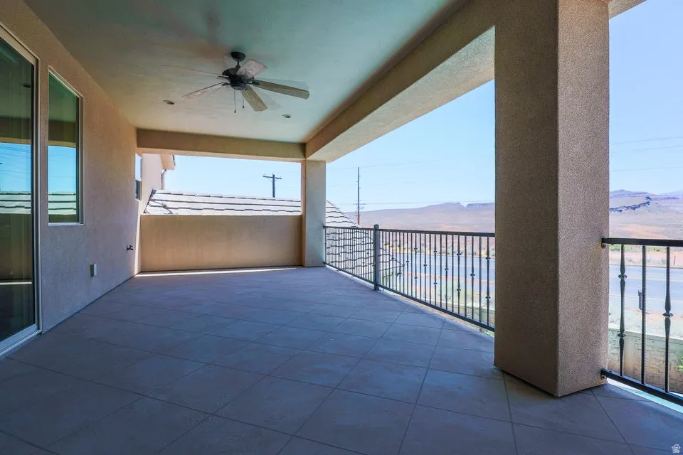 Expansive covered patio featuring large format tile flooring, a ceiling fan, recessed lighting, and a decorative metal railing