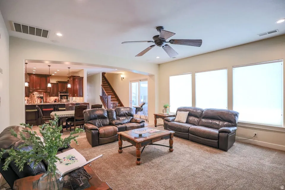 Open-concept living area with carpet flooring and recessed lighting