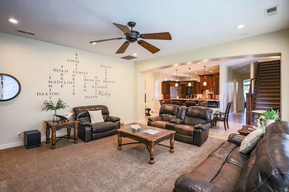 Spacious living area featuring carpet flooring, recessed lighting, and a ceiling fan