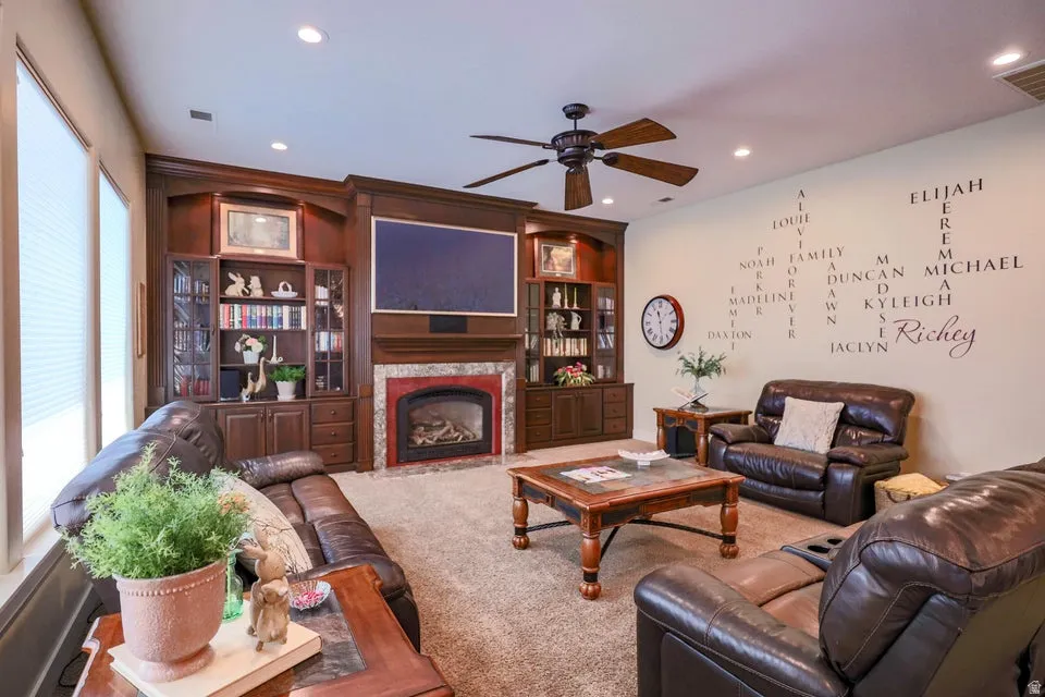 Living area featuring a floor-to-ceiling custom entertainment center with rich wood-finish cabinetry, integrated shelving, and a built-in fireplace with a red-toned surround