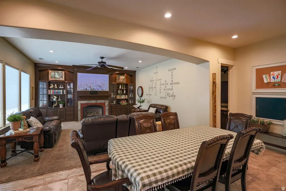 Spacious living area featuring a built-in entertainment center, gas fireplace with a tiled surround, and recessed lighting