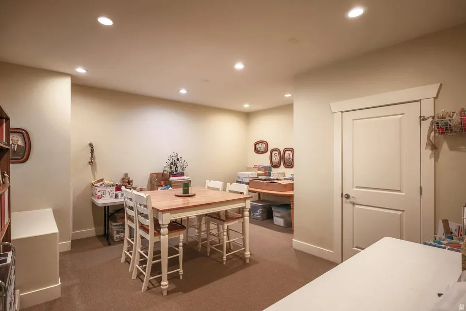 Recessed lighting illuminates this room, featuring neutral-toned walls and carpet flooring