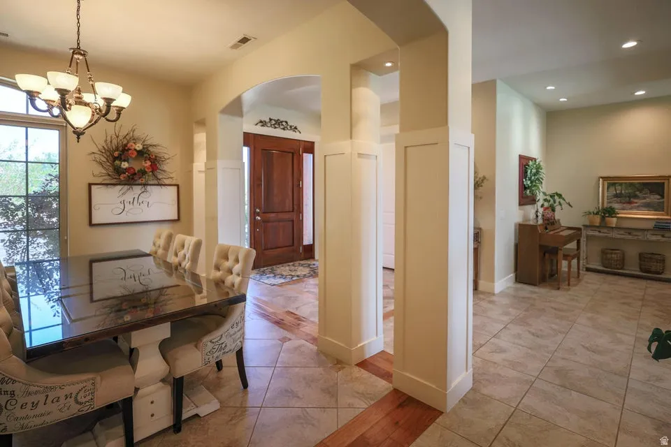 Spacious dining area featuring a chandelier, large patio door, and tile flooring