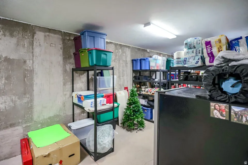 Unfinished basement area featuring concrete walls and ample storage space