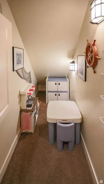 Carpeted under-stair alcove with integrated wall sconces and white painted trim