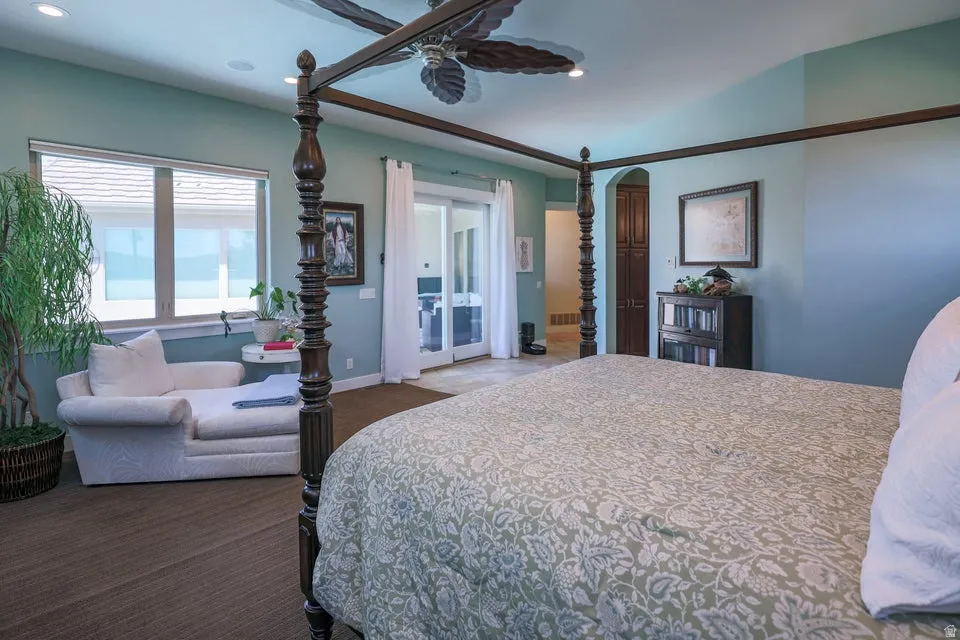 Spacious bedroom featuring light blue walls, recessed lighting, a ceiling fan, and large windows with blinds