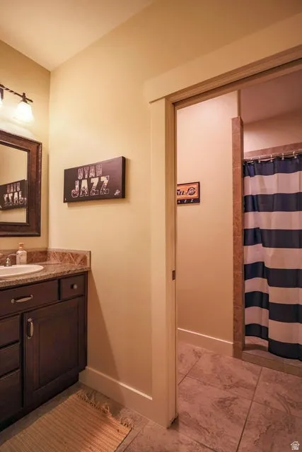 Bathroom vanity featuring dark wood cabinetry, a light-colored countertop with a built-in sink, and a framed mirror