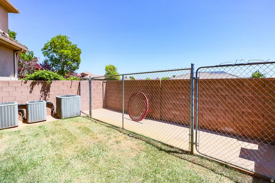 Enclosed utility area featuring a chain-link fence and concrete pad