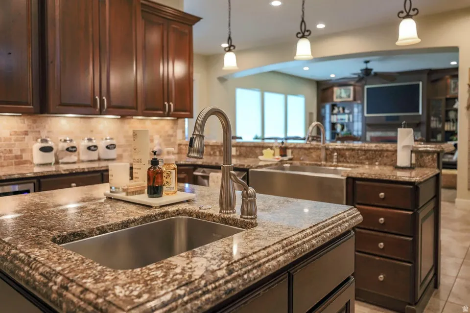 Kitchen island featuring a stainless steel undermount sink and a brushed nickel pull-down faucet
