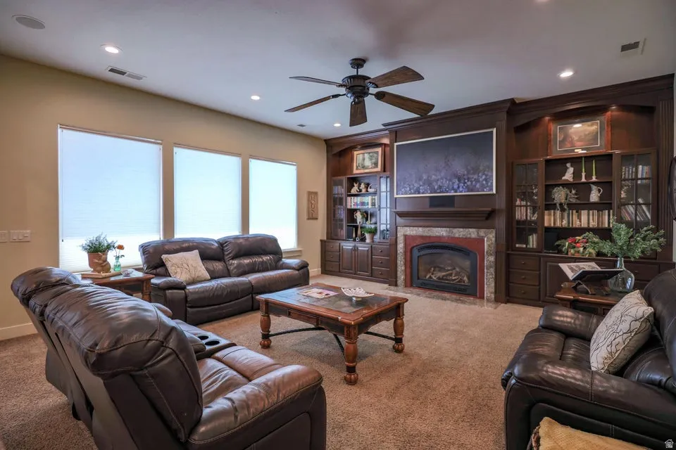 Living area featuring a floor-to-ceiling built-in entertainment center with a fireplace, recessed lighting, and a ceiling fan