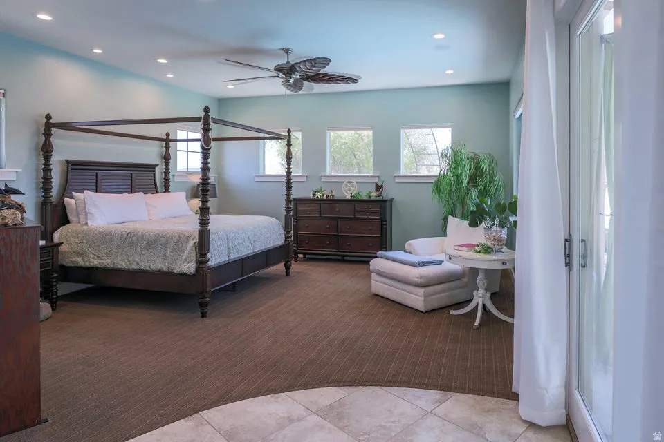 Spacious room featuring a ceiling fan, recessed lighting, and multiple windows