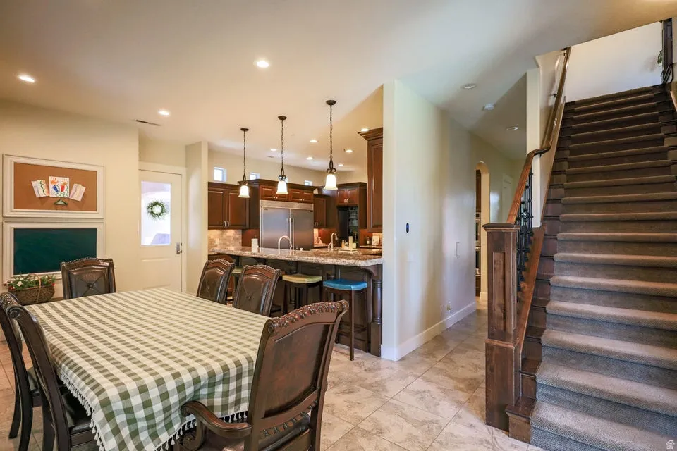Expansive dining area with tile flooring, recessed lighting, and a view of the kitchen