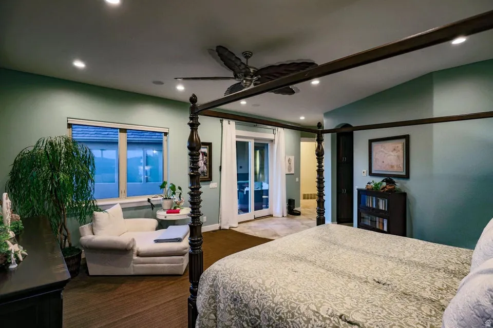 Spacious sleeping area with vaulted ceiling, recessed lighting, and a ceiling fan