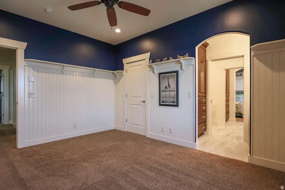 Room featuring wainscoting and a deep blue accent wall