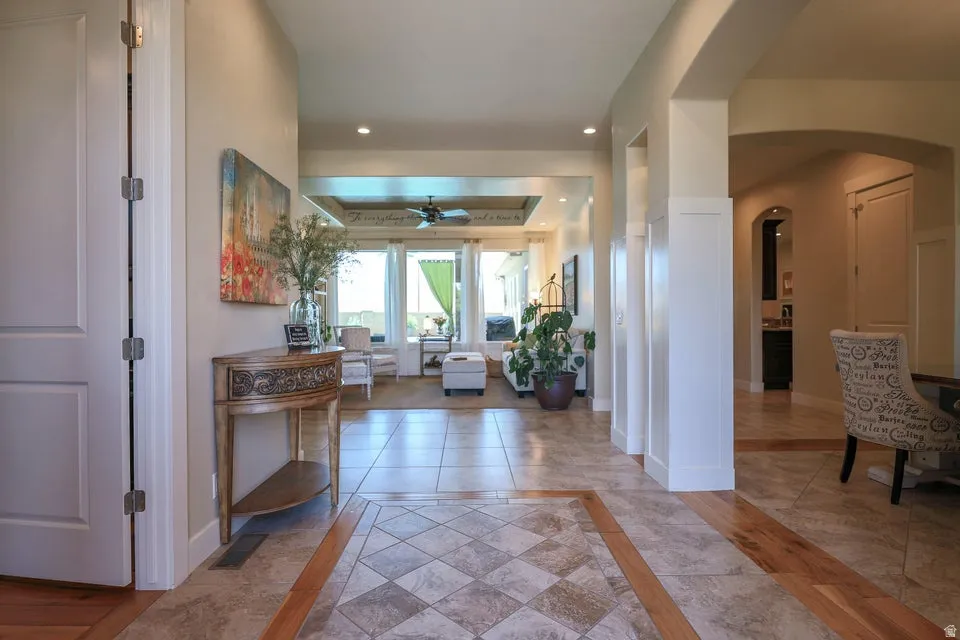 Entryway featuring tile flooring with decorative inlay, wood-finish flooring accents, recessed lighting, and archways leading to additional rooms