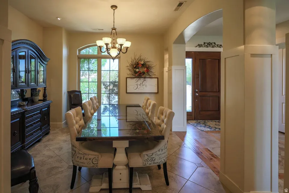 Dining area featuring tile flooring, an arched entryway, and a large window with grid panes