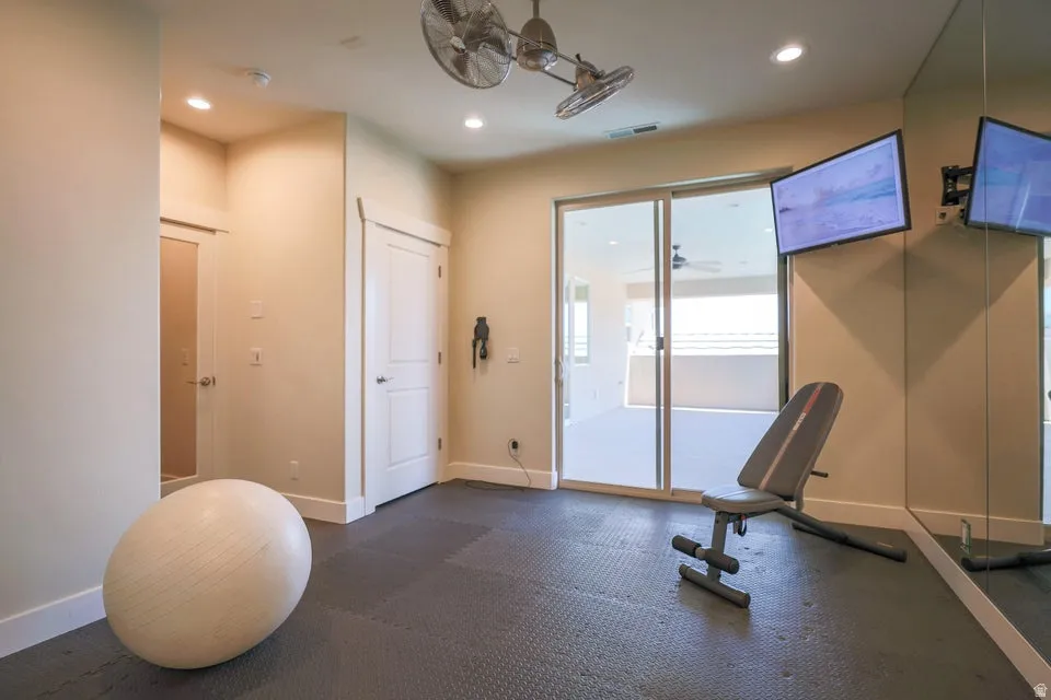 Interior room featuring dark interlocking floor tiles, recessed lighting, and dual ceiling fans