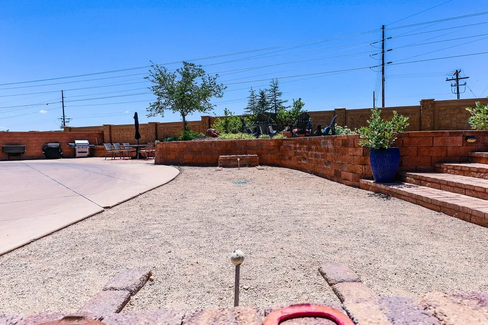 Expansive outdoor area featuring a concrete patio, gravel landscaping, and tiered retaining walls crafted from block pavers