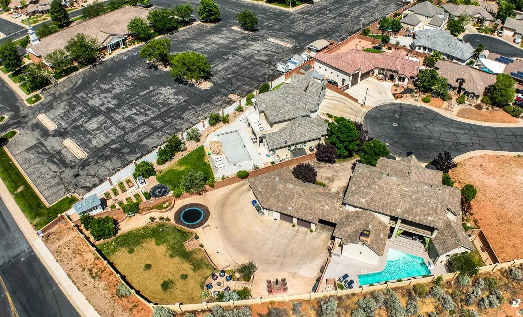 Expansive property featuring multiple structures, an inground swimming pool, and a large paved parking area