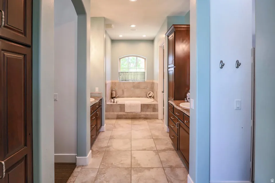 Soaking tub with a tiled surround beneath an arched window