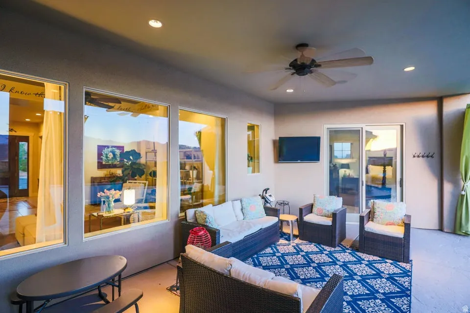 Covered patio featuring recessed lighting, a ceiling fan, multiple large windows, and a sliding glass door