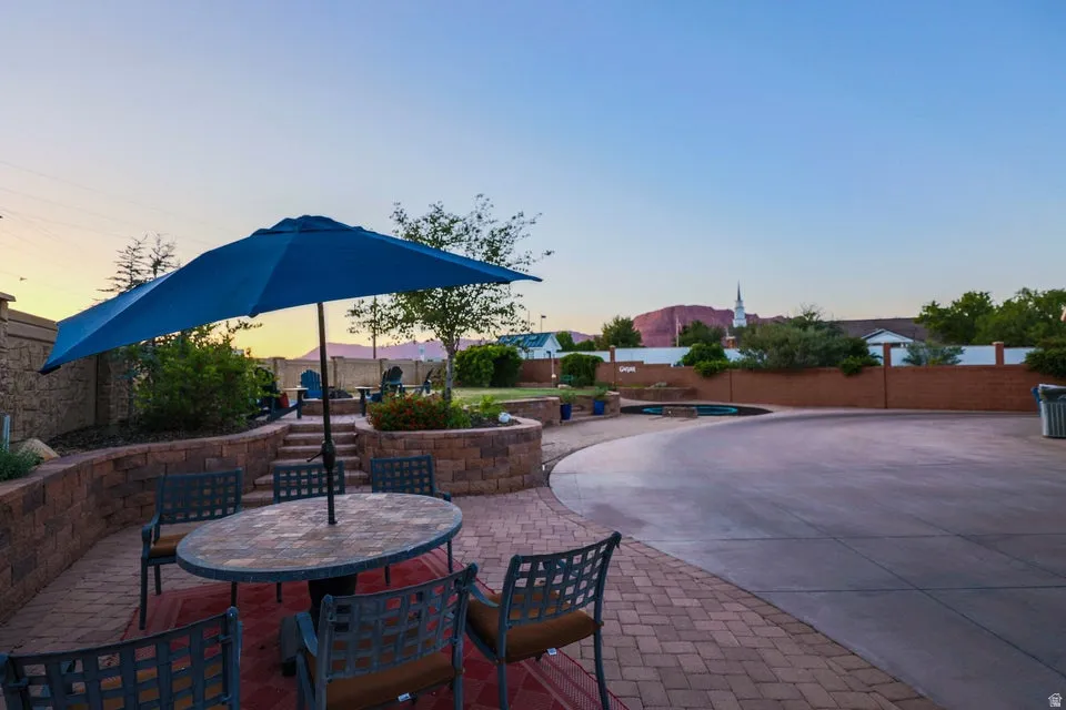 Multi-level patio featuring paver stone hardscaping, tiered stone retaining walls, and a built-in swimming pool