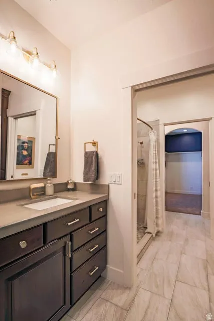 Bathroom featuring a dark wood-finish vanity with ample storage, a rectangular undermount sink, and a light-toned countertop