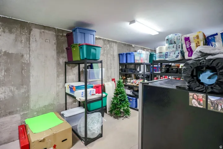 Unfinished basement area featuring concrete walls and ample storage space