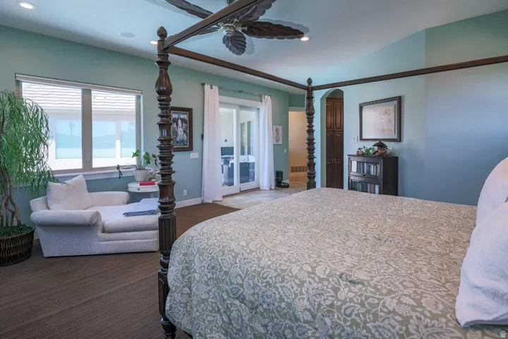 Spacious bedroom featuring light blue walls, recessed lighting, a ceiling fan, and large windows with blinds