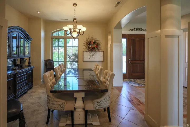 Dining area featuring tile flooring, an arched entryway, and a large window with grid panes
