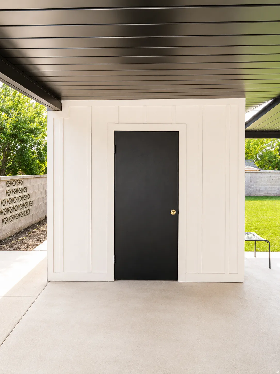 Covered patio area featuring a black paneled ceiling and clean concrete flooring