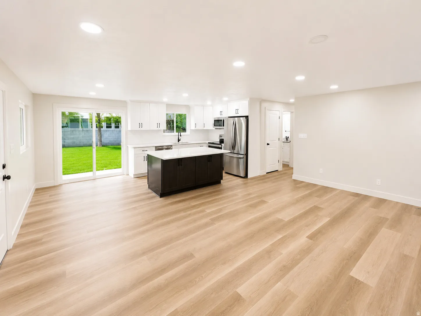 Open-concept living space featuring wood-finish flooring and recessed lighting