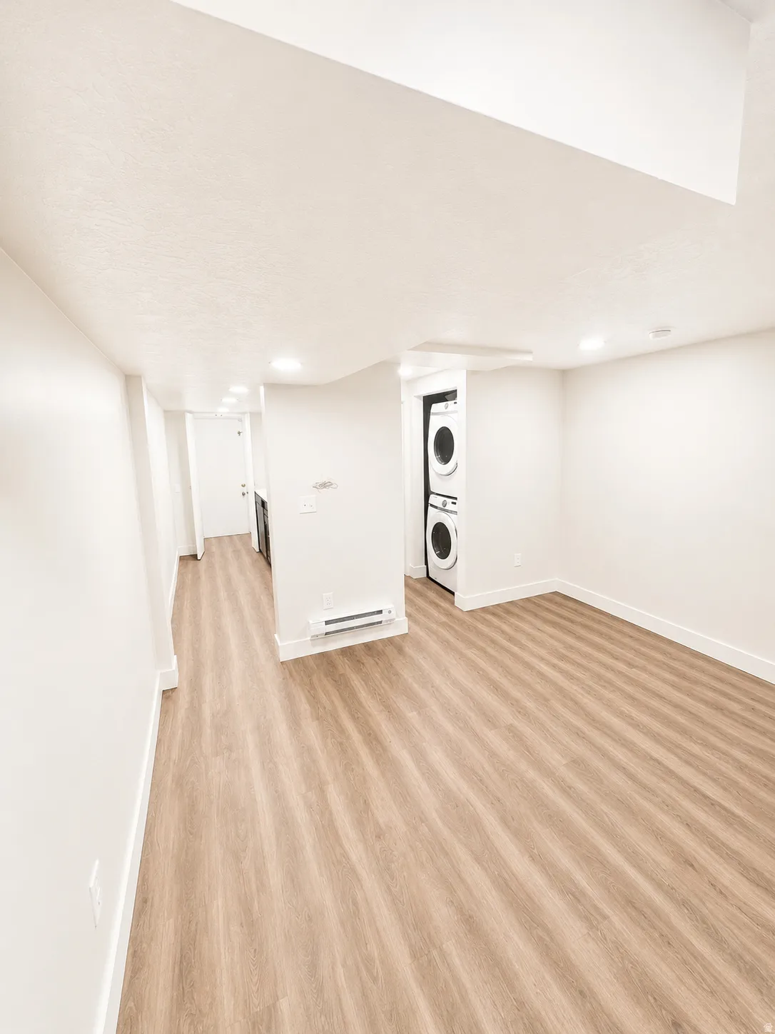 Spacious interior with wood-finish flooring, recessed lighting, and a neutral color palette