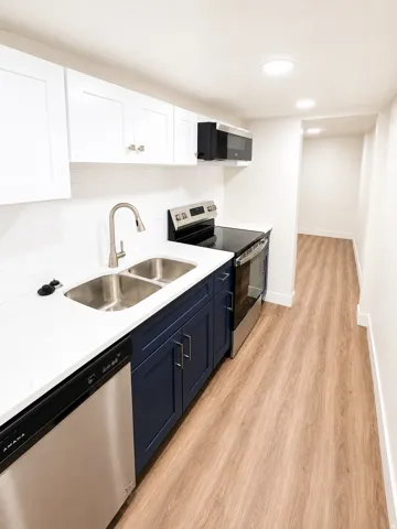 Kitchen featuring white shaker-style upper cabinetry, navy blue lower cabinetry, and a white subway tile backsplash