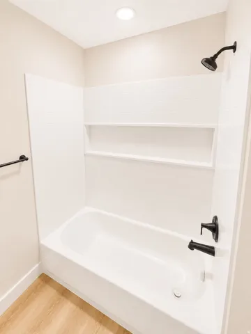 Bathtub and shower combination featuring white subway tile surround