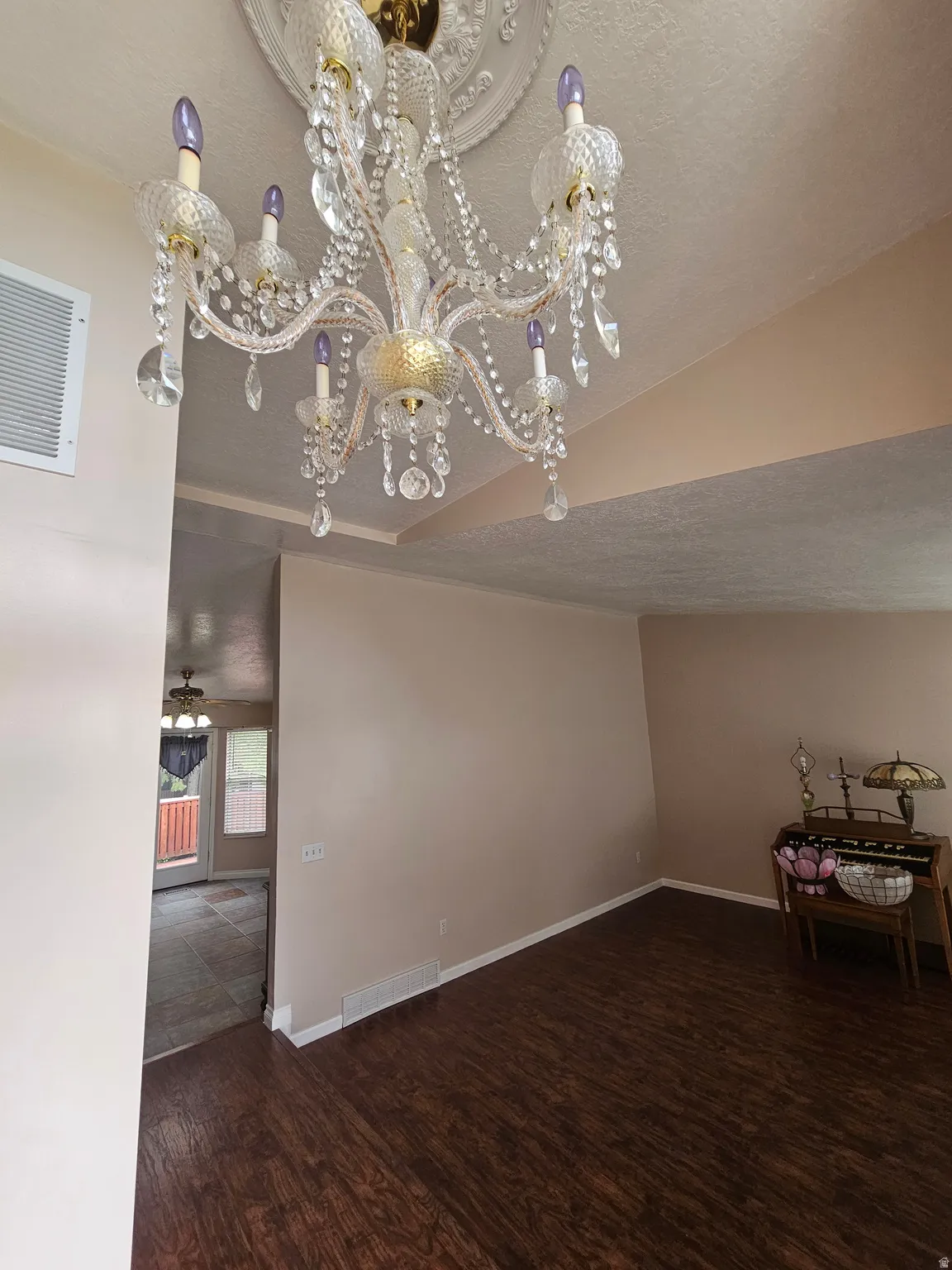 Formal room with a decorative chandelier, wood-finish flooring, and neutral wall paint