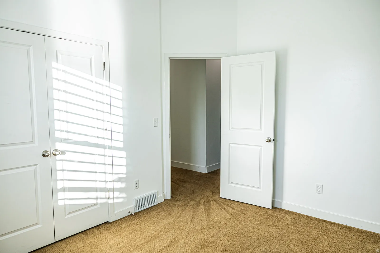 Room featuring white walls and neutral tone carpet flooring