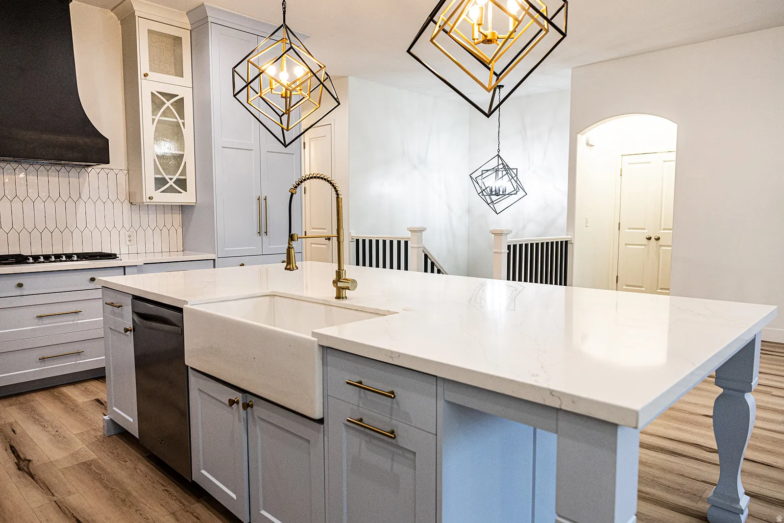 Kitchen island featuring a white farmhouse sink and a gooseneck faucet