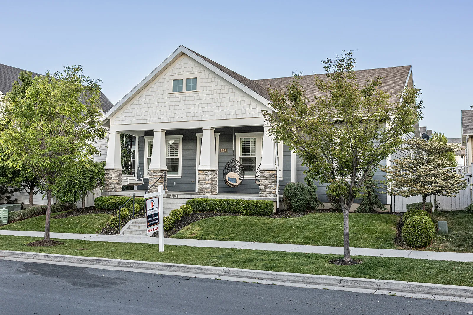 Craftsman-style facade with a covered front porch featuring stone accents and white columns
