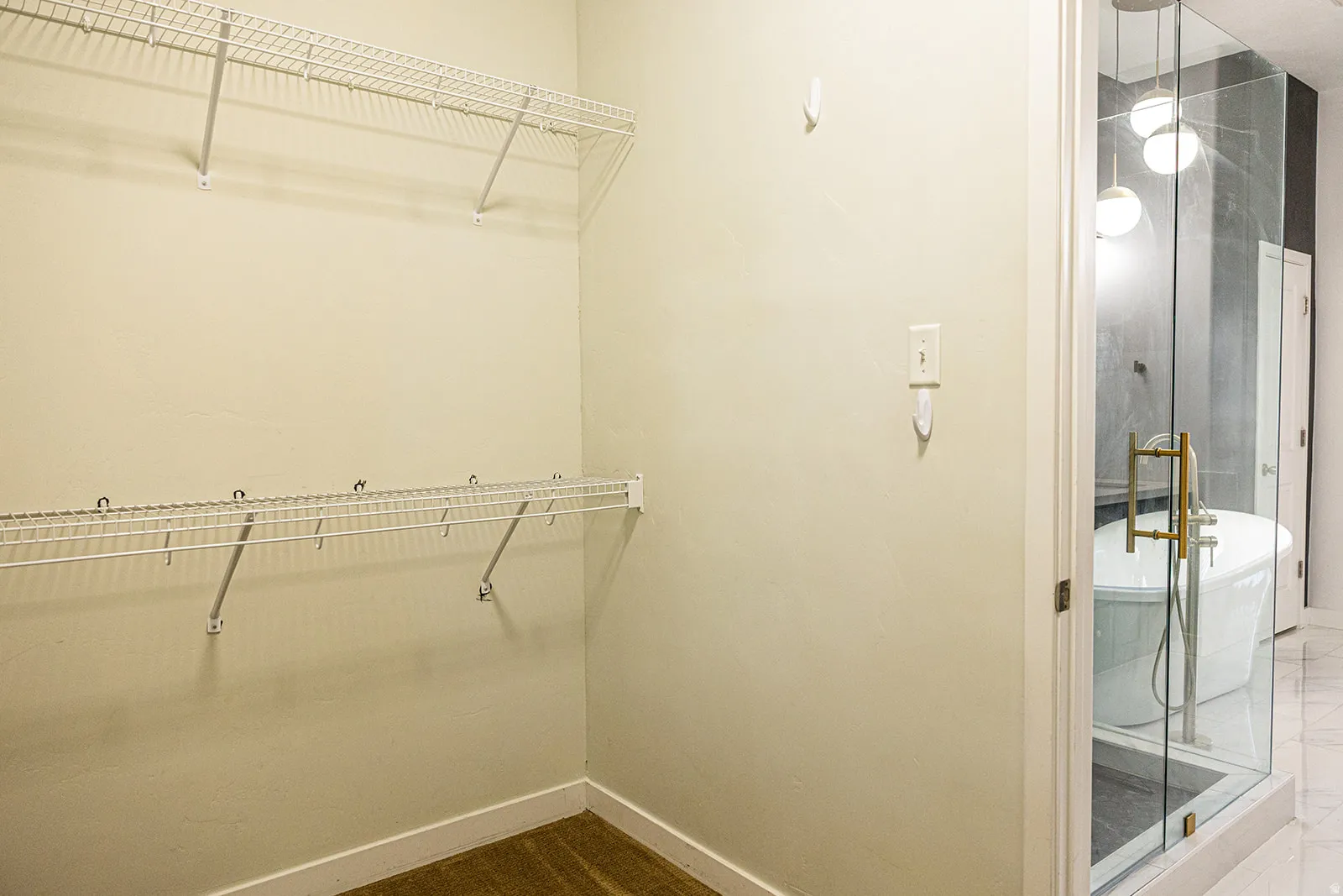 Walk-in closet featuring two levels of wire shelving, integrated hanging rods, and wood-finish flooring