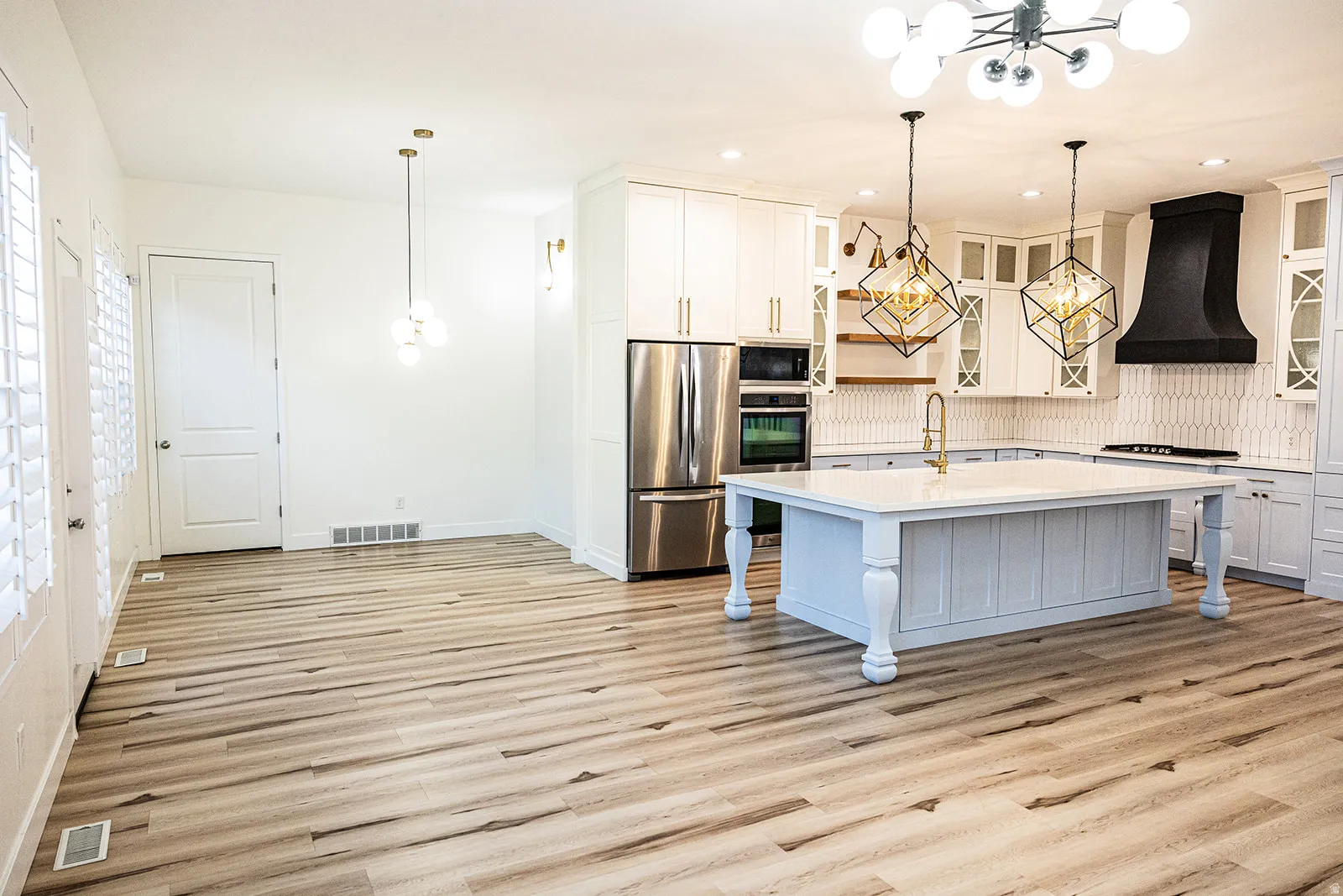 Open-concept kitchen and dining area featuring light wood-finish flooring