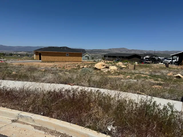 Unfinished residential structure featuring plywood sheathing and a dark shingle roof