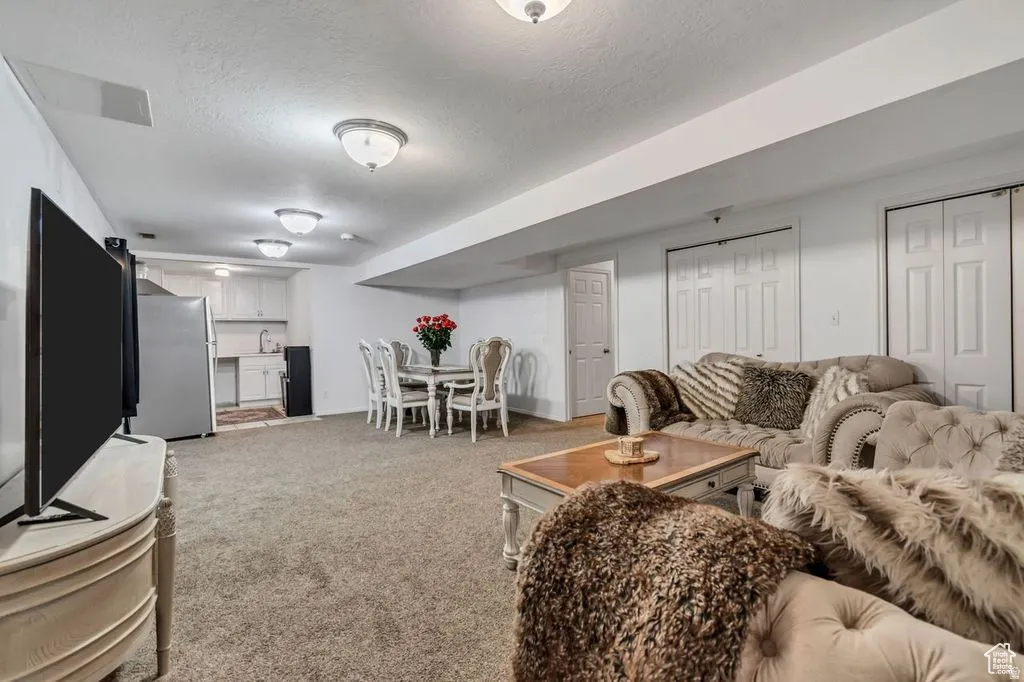 Spacious lower-level area with neutral carpet flooring, recessed lighting, and a white ceiling